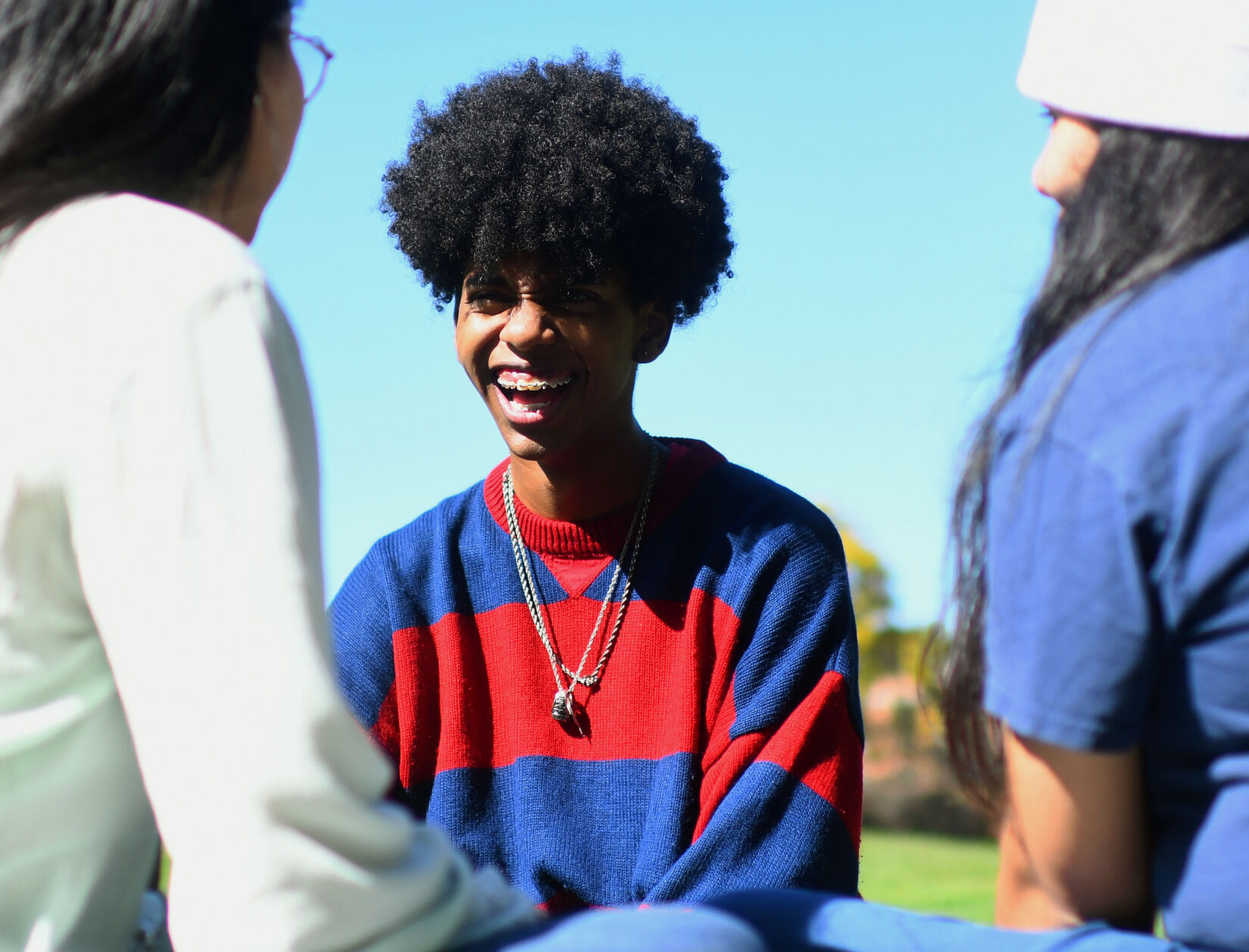 Anthony Moses III, center, laughs at commentary made by friends Anahi Alvarez, right, and Maria Yepez, left